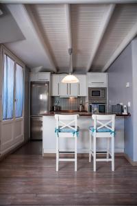 a kitchen with two white stools at a kitchen counter at Apartamento Jaca Snow in Jaca