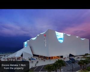 a large white building with people in front of it at The Wave Residence in Malacca