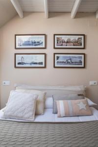 a bedroom with a white bed with three pictures on the wall at Apartamento Jaca Snow in Jaca