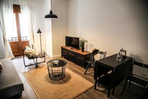 a living room with a tv and a table and chairs at Apartamentos Dacosta in Ribadeo