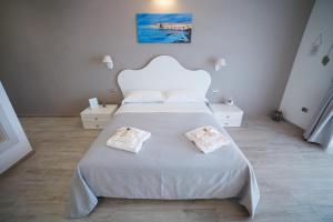 a bedroom with a large white bed with towels on it at La seconda Luna in Pollutri