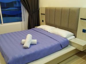a bed with two white towels sitting on it at The Wave Residence in Malacca