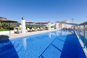 a large swimming pool with chairs and umbrellas at Gran Hotel Soller in Sóller