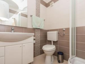łazienka z białą toaletą i umywalką w obiekcie Apartment F-3 Klimno w mieście Klimno