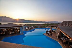 a hotel with a pool with a sunset in the background at Residence Stella Di Gallura in Porto Rotondo