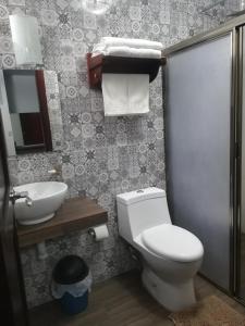 y baño con aseo y lavamanos. en Hotel La Finca, en Comitán de Domínguez