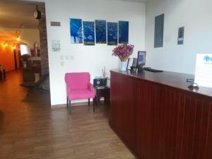 recepción con silla rosa en una habitación en Hotel La Finca en Comitán de Domínguez