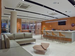 a lobby with a couch and a bar with chairs at Rio Hotel By Bourbon Campinas in Campinas