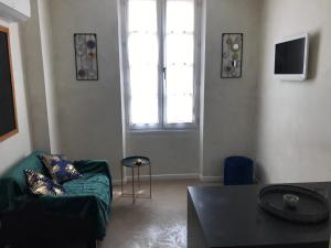 a living room with a green couch and a window at ALBI HOME - Vigan in Albi