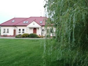 a white house with a red roof at Babie Lato in Włodarka