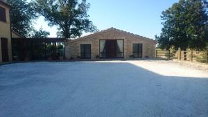 a house with a driveway in front of a building at Agriturismo "Le Piagge" in Castelplanio