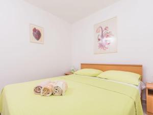 sypialnia z 2 łóżkami z zieloną pościelą i różami w obiekcie Apartment F-3 Klimno w mieście Klimno