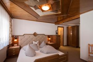 sypialnia z dużym łóżkiem z poduszkami w obiekcie Hotel Tanzer w mieście Ischgl