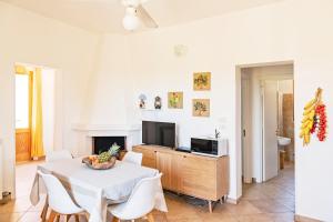 een woonkamer met een tafel en een tv bij Villa Nanni in Gallipoli