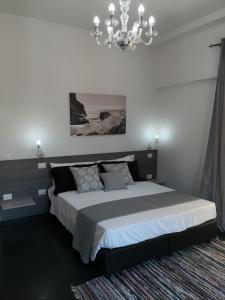 a bedroom with a large bed and a chandelier at Tropea Hermés House in Tropea