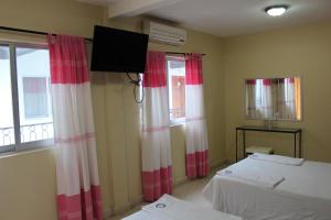 a room with two beds and a flat screen tv at Hotel Casablanca Tuxtla in Tuxtla Gutiérrez