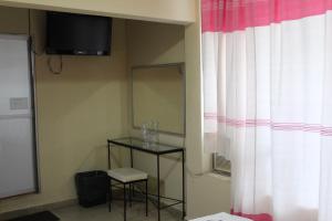 a room with a table and a mirror and a curtain at Hotel Casablanca Tuxtla in Tuxtla Gutiérrez