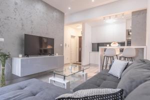 a living room with a gray couch and a tv at Apartman Danica No.2 in Banja Koviljača