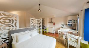 a bedroom with a white bed and a kitchen at Rua de São Bento n.123 in Vila do Conde