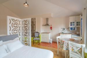 a bedroom with a bed and a table and a kitchen at Rua de São Bento n.123 in Vila do Conde