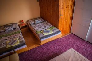 een kamer met 2 bedden en een paars tapijt bij Apartmán Štrba in Štrba