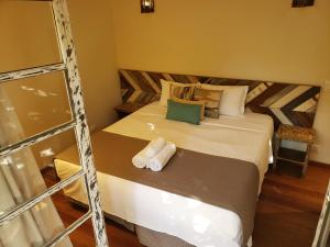 um quarto com uma cama com duas toalhas em Pousada Camburi em Camburi