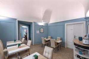 une salle à manger avec des murs bleus, des tables et des chaises dans l'établissement Aragonese Luxury Rooms, à Naples