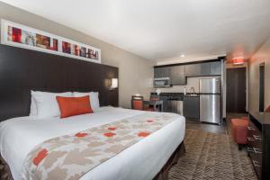 a hotel room with a large bed and a kitchen at Hawthorn Suites Las Vegas in Las Vegas