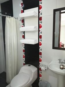 y baño con aseo blanco y lavamanos. en Pandora hotel colca en Chivay