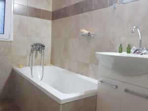 a bathroom with a bath tub and a sink at Arismari Apartments in Zíros