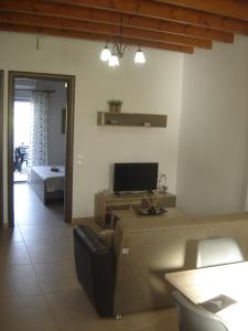 a living room with a couch and a tv at Arismari Apartments in Zíros