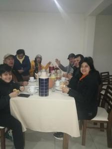 een groep mensen die rond een tafel zitten bij Pandora hotel colca in Chivay