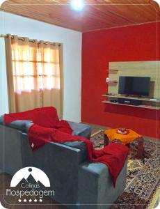 sala de estar con sofá y TV en Hospedagem Colinas, en Aiuruoca