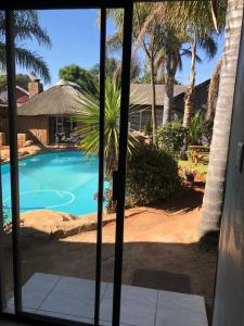 a view from the door of a resort with a swimming pool at Africaren Budget Stay in Kempton Park