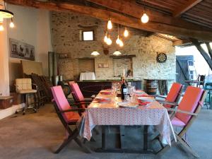 a dining room with a table and pink chairs at French Fields Luxury Glamping Original Mongolian Yurt in Le-Vieux-Cérier