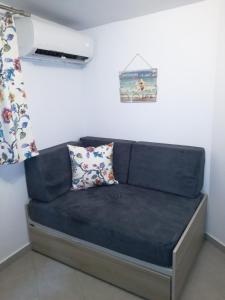 een blauwe bank met twee kussens in een kamer bij Maria's Home in Kavala
