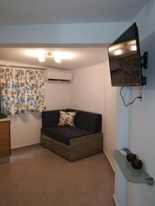 Il comprend un salon doté d'un canapé et d'une télévision à écran plat. dans l'établissement Maria's Home, à Kavala