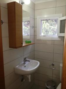 uma casa de banho com um lavatório e uma janela em Maria's Home em Kavala