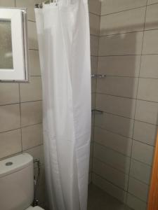La salle de bains est pourvue d'une douche avec rideau de douche blanc. dans l'établissement Maria's Home, à Kavala