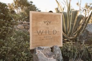 a sign in front of a cactus at The Wild by Interni in Kalafatis
