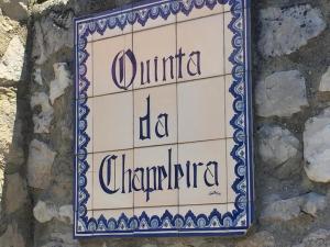 a sign on the side of a stone wall at Quinta da Chapeleira em Azeitão in Azeitao