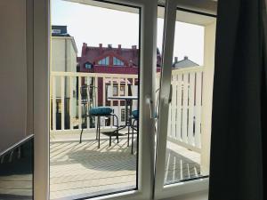 an open door to a balcony with a table and chairs at Ahoj Apartments in Ustka