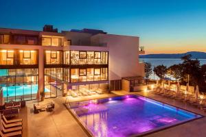 a large house with a swimming pool in front of it at Luxury Hotel Riva in Malinska