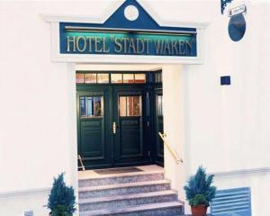 
a stairway leading to a building with a blue door at Hotel Stadt Waren in Waren

