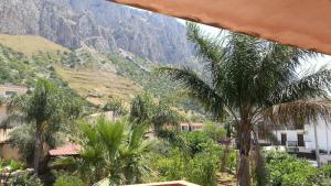 - une vue sur une montagne bordée de palmiers et de bâtiments dans l'établissement Cinisi 89 B&B, à Cinisi