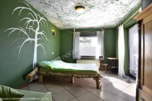 1 dormitorio con 1 cama en una pared verde en Agroturystyka Sielana, en Kostrzyca