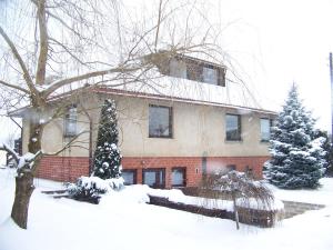 una casa está cubierta de nieve delante de ella en Agroturystyka Sielana, en Kostrzyca