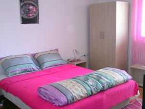a pink bed with pillows in a bedroom at Sava in Soko Banja