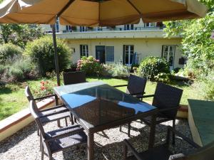 un tavolo e sedie con ombrellone su un patio di Maison Baxter a Prats-de-Mollo-la-Preste