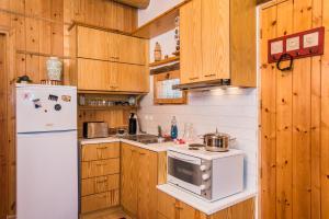 a kitchen with wooden cabinets and a white refrigerator at ARADENA TRADITIONAL House 1 in Arádhaina